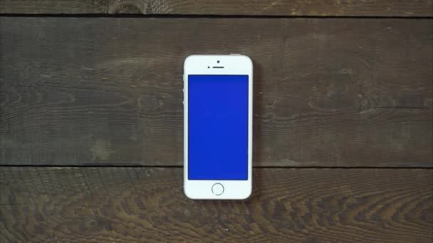 缩放在手带蓝色屏幕智能手机 — 图库视频影像