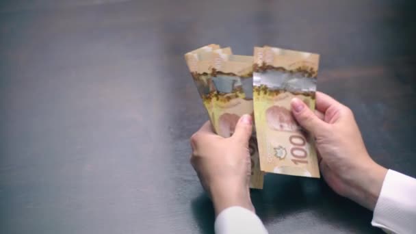 Погляд жінки підрахунку багато Канадський 100 рахунки — стокове відео
