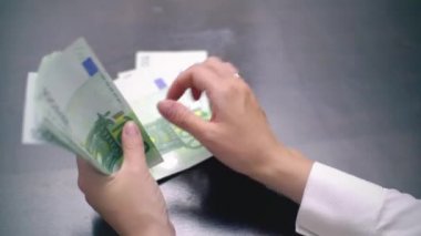 Birçok Euro sayma bir kadın görünümünü 100 faturaları
