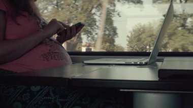 Bir trende Smartphone ile çalışan hamilelik kadın