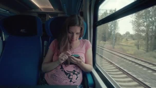 Mulher grávida trabalhando com smartphone em um trem — Vídeo de Stock