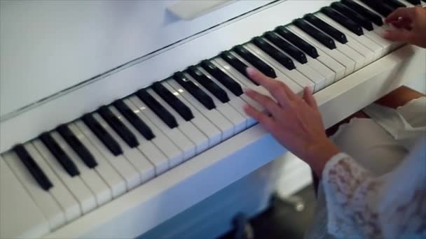 Mãos de mulher tocando piano branco — Vídeo de Stock