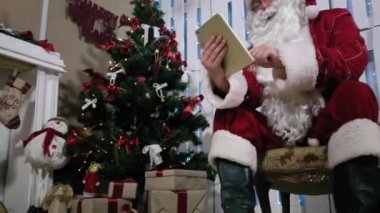 Santa inşaat üstünde dijital Tablet Noel ağacı hediye, şömine ve Noel ağacı hediye Oda.