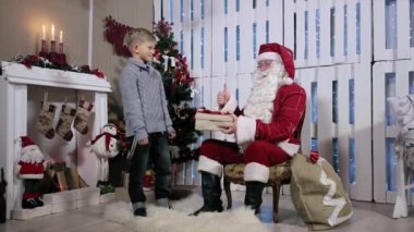Mevcut Noel Baba ve onun kulak sallıyor ve Santa sallanan eller çocuktur