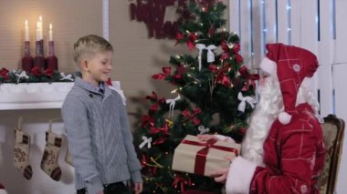 Gri kutusu mevcut Noel Baba ve onun kulak sallıyor bir çocuktur
