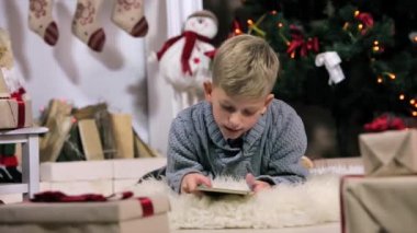 Küçük çocuk yerde yatan, dijital ekran, Şömine ve Noel Ağacı ile beyaz Oda, frontal, Orta kullanın