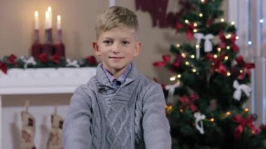 Küçük çocuk başparmak ups veren, gülümseyen, kamera bakmak, Şömine ve Noel Ağacı ile beyaz Oda, Orta