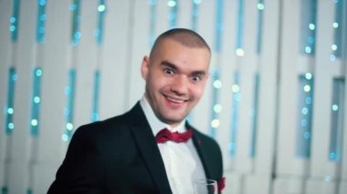 Siyah elbiseli güzel adam bir cam şömine ve Noel ağacı ile beyaz odada elinde tutan