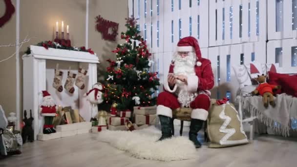 Weihnachtsmann-Zoom-Touchscreen auf Smartphone, Zimmer mit Kamin und Weihnachtsbaum, Geschenke — Stockvideo