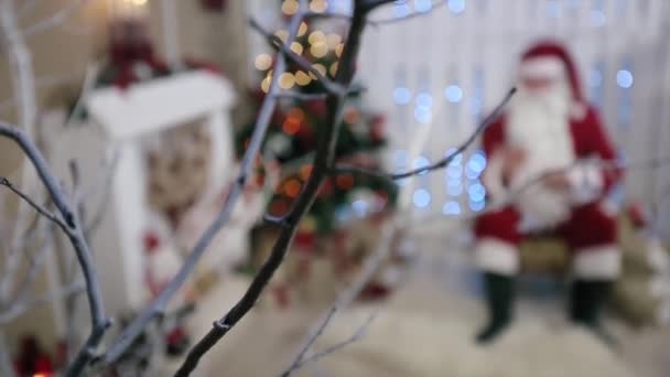 Weihnachtsmann sitzt und arbeitet am Smartphone, Zimmer mit Kamin und Weihnachtsbaum, Geschenke. — Stockvideo