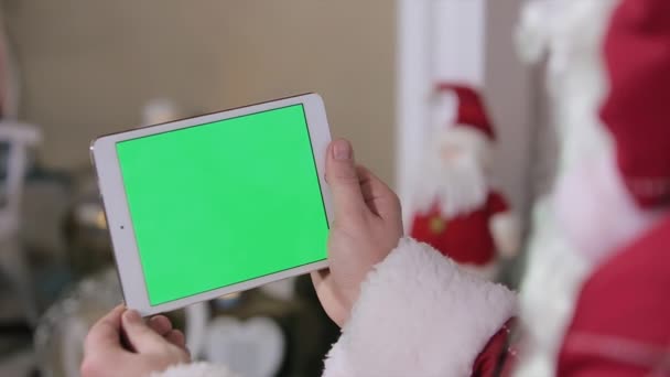 Le Père Noël travaille sur l'écran vert de tablette numérique. Tablette avec écran vert en mode paysage. Facile à suivre et à saisir. Codec QG ProRes 