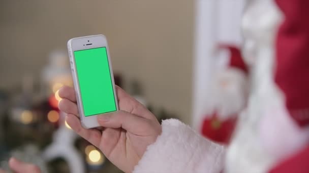 Weihnachtsmann mit Smartphone mit grünem Bildschirm. Smartphone mit grünem Bildschirm im vertikalen Modus. leicht zu verfolgen und zu tasten. prores hq codec — Stockvideo