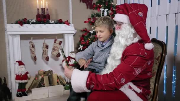 Weihnachtsmann zeigt, wie man ein Geschenk auf Tablets auswählt — Stockvideo