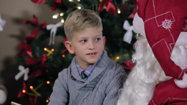 Jongen zit in de Santas schoot, communiceren — Stockvideo