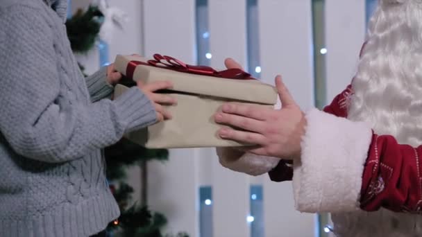 Маленький мальчик открывает подарок от Санты, улыбаясь — стоковое видео