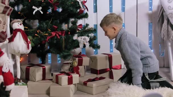 O menino correu para a árvore, extratos de cabines telefônicas, sala branca com lareira e árvore de Natal, Médio — Vídeo de Stock