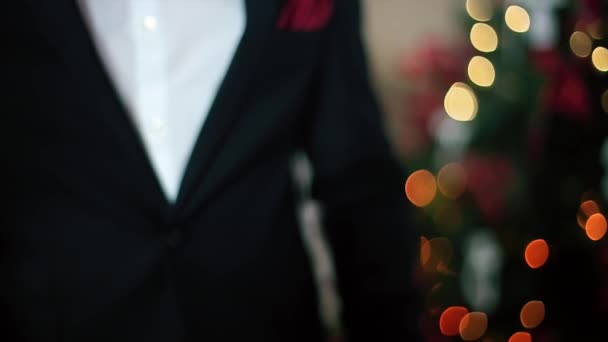 La mujer le da al hombre un regalo de traje negro con cinta roja — Vídeos de Stock