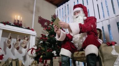 Santa döndürmek dijital Tablet odası şömine ve Noel ağacı üzerinde