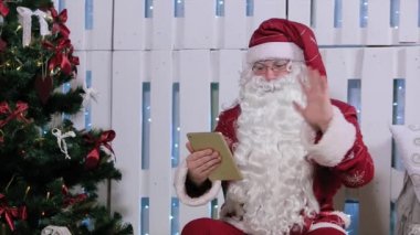 Noel Baba olduğunu Sit ve parmak kadar dijital Tablet, şömine ve Noel ağacı, hediyeler Oda.