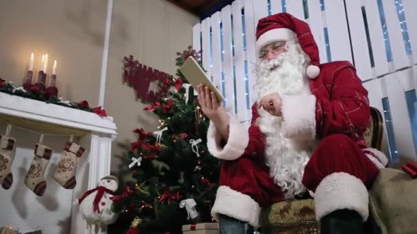 산타 타입 터치 스크린 태블릿 방에 벽난로와 크리스마스 트리. — 비디오