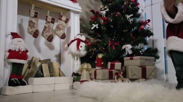 Santa föredrag om Digital Tablet julgran gåva, rum med öppen spis och julgran presenter. — Stockvideo