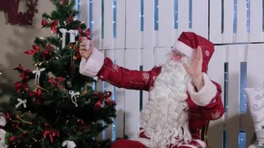 Noel Baba olduğunu oturmak ve onun Smartphone, Şömineli Oda ve Noel ağacı, hediyeler Selfi yapmak.