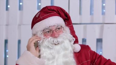 Noel Baba Noel ağacı ve hediyeler ile odasında onun telefonu konuşurken