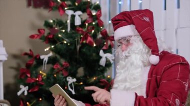 Noel Baba Noel ağacı ve hediyeler ile odada dijital Tablet sayfa açar