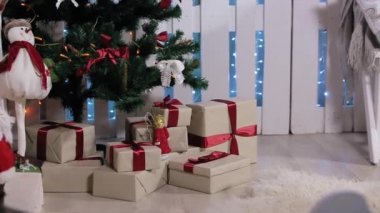 Çocuk ağaca koştu, bir hediye ile bir kutu, onu sallar, çeker ve akıllı telefon, Şömine ve Noel Ağacı, Orta ile beyaz Oda düşünüyor