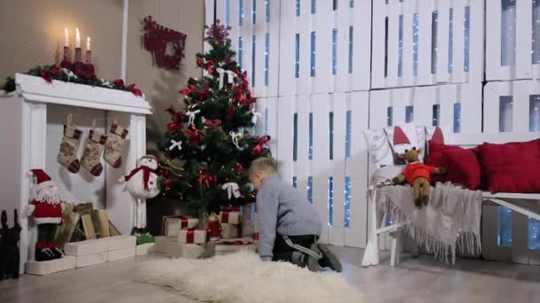 O menino correu até a árvore, extrai de cabines telefônicas, considera Telefone, Quarto branco com Lareira e Árvore de Natal — Vídeo de Stock