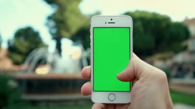 Park arka plan çeşmenin üzerinde telefon App kullanarak