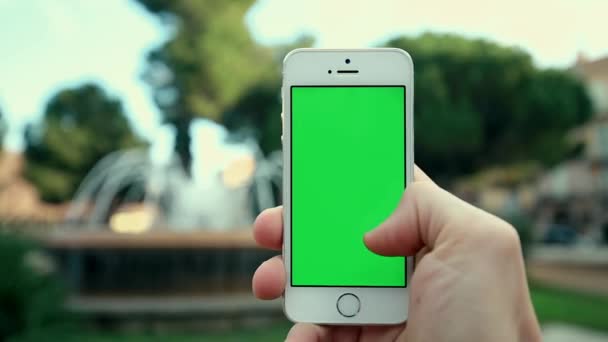 Telefon-App im Park vor Brunnenhintergrund — Stockvideo