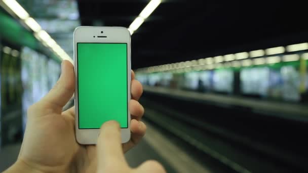 Hombre utiliza su teléfono pantalla verde en la estación de metro — Vídeos de Stock