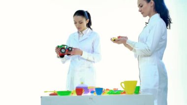 Kadın laboratuvar plastik oyuncaklar beyaz odada kalitesini kontrol edin.