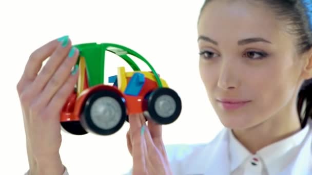 Female Worker Checks the Quality of Color Plastic Toy Tractor — Stock Video