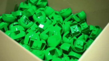 Bir karton kutunun içinde düşen oyuncak plastik parçalar