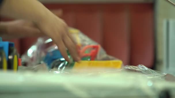 Жінка Дитяча упаковка Іграшка Трактор в поліетилену і відправляє його — стокове відео