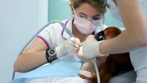 Кавказский стоматолог, посещающий молодую женщину в стоматологической студии, люди и гигиена полости рта, медицинское обслуживание в клинике — стоковое видео