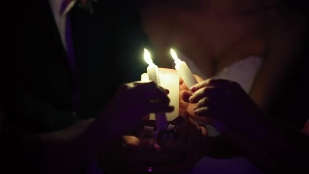 Menyasszony és a vőlegény egy égő gyertyát tart — Stock videók