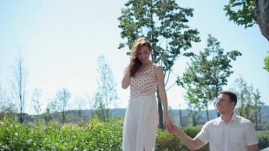 Mutlu genç iki yürüyor yaz alanı ve gülen, tutuşup dışarıda eğleniyor bir geniş alan ile yürümek. Erkek ve kadın üzerinde çayır ağır çekim Full Hd 1080p