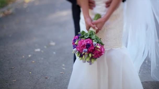 多彩的婚礼花束在背景上的新郎和新娘的手的特写 — 图库视频影像