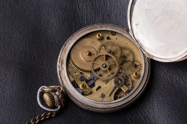 Old clock mechanism on black leather background — Stock Photo, Image