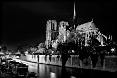 Siyah ve beyaz Notre Dame Katedrali, gece Paris, Fransa'da Seine Nehri üzerinde.
