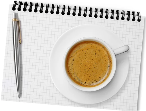 Koffiekopje op notebook — Stockfoto
