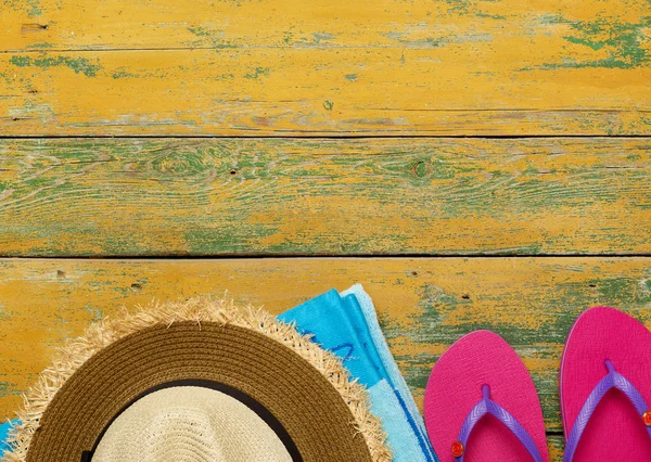 Straw hat, towel and slippers on wood — Stock Photo, Image