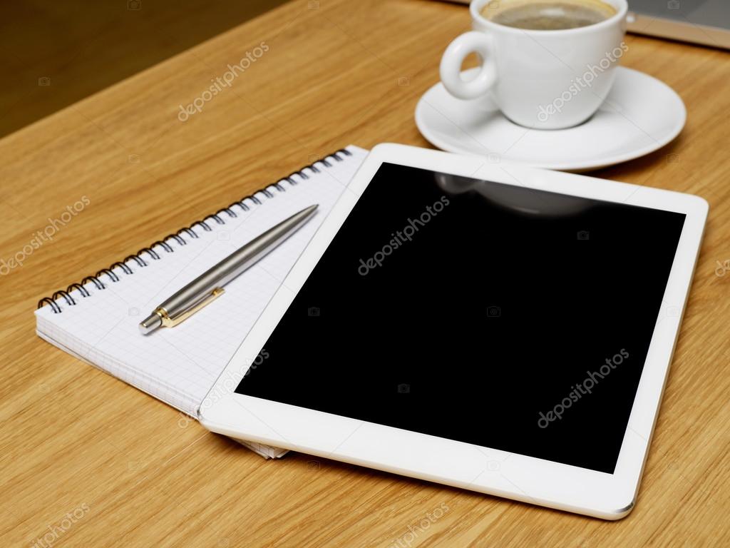 Tablet, notebook and coffee on desk