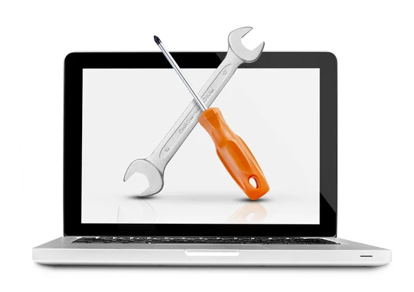 Screwdriver and wrench on laptop — Stock Photo, Image