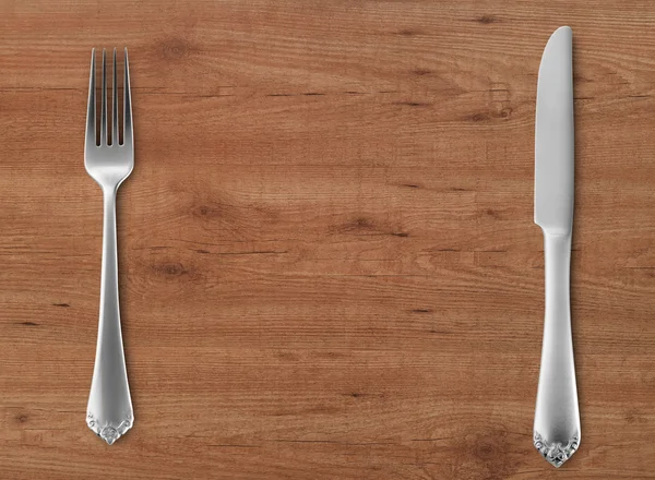 Table knife and fork on wood — Stock Photo, Image