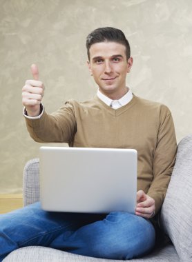 Adam kanepede ok işaret gösteren dizüstü bilgisayar ile