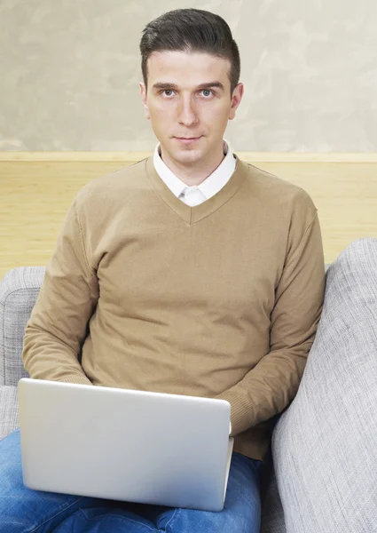 Homem com laptop olhando para a câmera — Fotografia de Stock